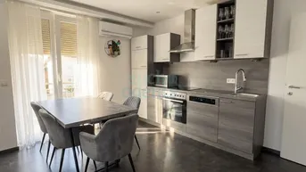 Moderne Einbauküche mit Essbereich, ausgestattet mit modernen Geräten und direktem Zugang zum Balkon, hell und freundlich.