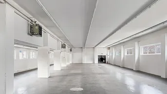 Großer, leerer Gewerberaum mit Betonboden, hohen Decken und sichtbaren Lüftungsanlagen.