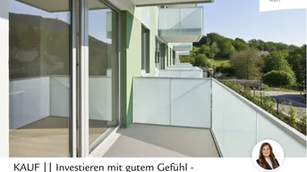Moderner Balkon mit Glasbrüstung und weitem Blick ins Grüne, Teil eines Neubaus.