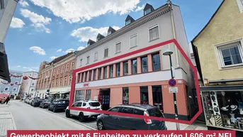 Ansicht des Gewerbeobjekts mit sechs Einheiten von der Straße, umgeben von anderen Gebäuden und parkenden Autos.