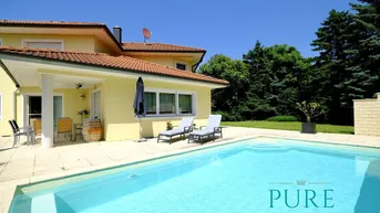 Großzügiger Außenbereich mit Swimmingpool, Liegestühlen und überdachter Terrasse am Haus.