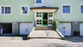 Eingangsbereich des Mehrfamilienhauses mit Rampe und Garagenzufahrten.