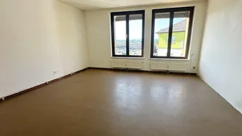 Geräumiges, unmöbliertes Zimmer mit zwei Fenstern und Blick auf die umliegende Bebauung.