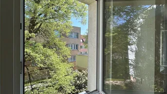 Blick aus dem Fenster auf grüne Bäume und die umliegende Wohnbebauung, die viel Privatsphäre bietet.