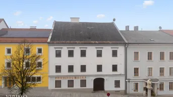 Historisches Gebäude mit traditioneller Architektur und Gasthaus-Beschriftung in einer Stadtansicht.