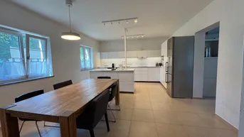 Geräumige offene Küche mit Essbereich, Kochinsel und modernen Geräten.