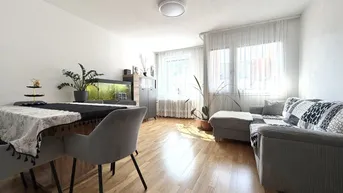 Helles Wohn- und Esszimmer mit Parkettboden, bequemer Couch und Esstisch für gesellige Stunden.