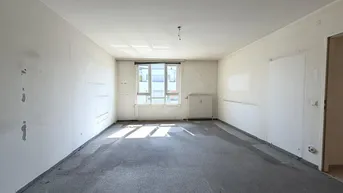 Helles, unmöbliertes Wohnzimmer mit Teppichboden und Fenster, bereit zur Renovierung.