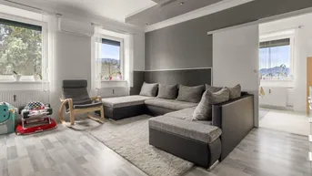Helles Wohnzimmer mit großem Ecksofa, modernem Decken-Design und Blick ins Grüne.