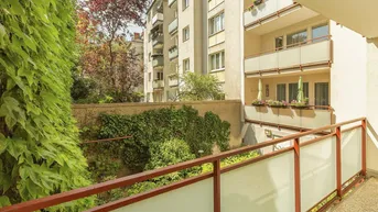 Geräumiger Balkon mit Blick auf begrünte Wände und andere Wohngebäude.