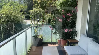 Möblierter Balkon mit Holzboden und Pflanzen, bietet einen angenehmen Außenbereich.