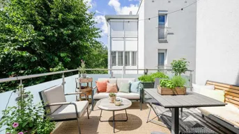 Möblierter Balkon mit gemütlicher Sitzecke, Pflanzen und Blick auf die Umgebung.