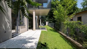 Eine moderne Terrasse mit direktem Zugang zum Garten und Blick auf die grüne Umgebung.