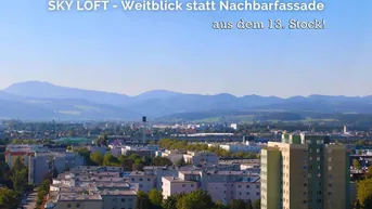 Weitblick über die Stadt mit Bergpanorama aus dem 13. Stock eines Hochhauses.