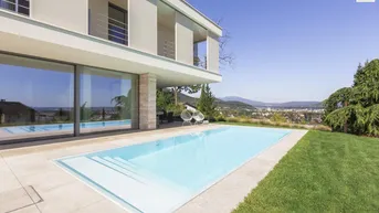 Moderner Außenbereich mit großem Pool, weitläufiger Rasenfläche und Panoramablick auf die Stadt.