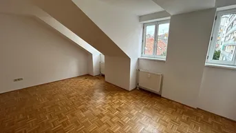 Helles Zimmer mit Parkettboden, weißen Wänden und Dachschrägen, ideal als Wohn- oder Schlafzimmer.