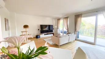 Heller Wohnbereich mit Holzfußboden, Klimaanlage und Zugang zu einem großen Balkon.
