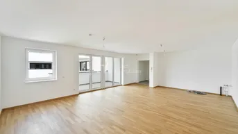 Helles und geräumiges Wohnzimmer mit Parkettboden und Zugang zu einem Balkon.