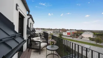 Balkon mit Sitzgelegenheiten und weitem Blick über die städtische Umgebung und Landschaft.