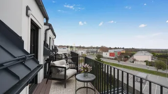 Möblierter Balkon mit Holzboden und Blick auf die Umgebung, ideal zum Entspannen im Freien.