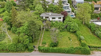 Luftaufnahme eines Hauses mit großem Garten und viel Grün in einer ruhigen Wohngegend.