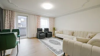 Helles Wohn- und Esszimmer mit Parkettboden, Stuckdecke und Zugang zum Balkon.