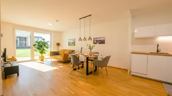 Helles, offenes Wohn- und Esszimmer mit Holzboden und Zugang zum Gartenbereich.