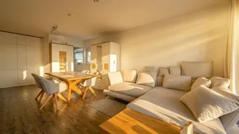 Helles, offenes Wohn- und Esszimmer mit modernem Design und Holzboden.