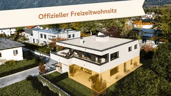 Moderne Villa mit Flachdach und großen Fensterfronten in alpiner Umgebung mit Bergblick.
