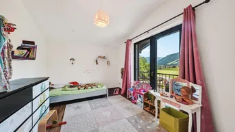 Mädchenzimmer mit Einzelbett, Schminktisch und Zugang zu einem französischen Balkon mit Bergblick.