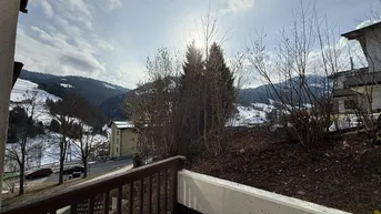 Panoramablick vom Balkon auf die idyllische, verschneite Berglandschaft und umliegende Natur.