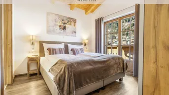 Gemütliches Schlafzimmer mit Doppelbett, Holzboden und malerischem Bergblick.