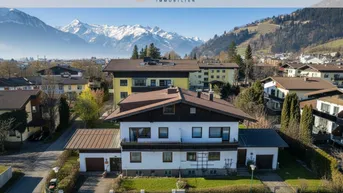Luftaufnahme eines Hauses mit traditioneller Architektur und beeindruckendem Bergblick in einer Wohngegend.