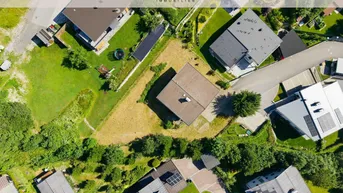 Senkrechte Luftaufnahme des Grundstücks mit dem Haus und umliegenden Gebäuden in einer grünen Umgebung.