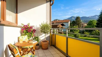 Heller Balkon mit Gartenmöbeln, Pflanzen und weitem Bergblick unter blauem Himmel.