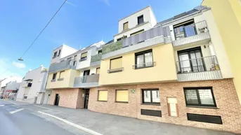 Moderne Wohnhausfassade mit Balkonen und gelben Akzenten unter blauem Himmel.