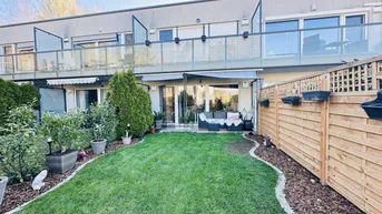 Gepflegter Gartenbereich mit Rasenfläche, Pflanzen und einer gemütlichen Terrasse am Haus.