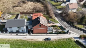 Luftaufnahme eines Einfamilienhauses mit Garten, umliegender Straße und ländlicher Umgebung.