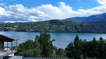 Panoramablick auf den See und die Berge von der Immobilie, umgeben von üppiger Natur.