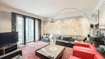 Geräumiges Wohnzimmer mit Ledersofas, großem Teppich und Zugang zu einem kleinen Balkon.