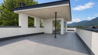 Geräumige Dachterrasse mit Fliesenboden und weitem Blick auf die Berge und die Landschaft.