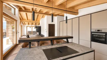 Moderne Küche mit Kochinsel, integriertem Backofen und offenem Blick auf den Essbereich.