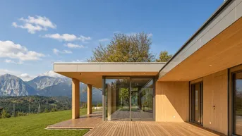 Weitläufige Holzterrasse mit Panoramablick auf die Berge und die grüne Hügellandschaft.