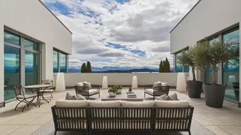 Große Dachterrasse mit bequemen Loungemöbeln und einem weiten Blick auf die Berge und die Landschaft.