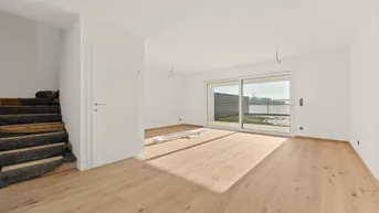Helles, unmöbliertes Wohnzimmer mit neuem Parkettboden und Zugang zur Terrasse.