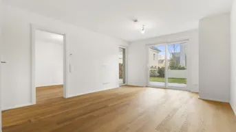 Helles, leeres Wohnzimmer mit Parkettboden und direktem Zugang zum privaten Gartenbereich.