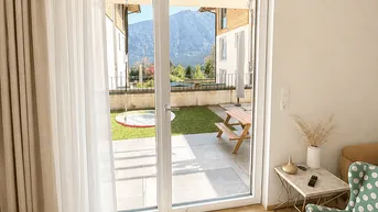 Helles Wohnzimmer mit Zugang zum Garten, Bergblick und moderner Einrichtung.