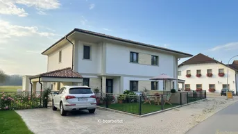 Modernes Einfamilienhaus mit weißer Fassade, Carport und gepflegtem Vorgarten.