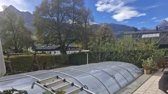 Überdachter Poolbereich im Garten mit Blick auf die umliegende Berglandschaft und viel Grün.