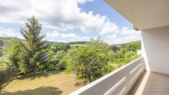Balkon mit weitem Blick über die grüne Hügellandschaft und den Garten.